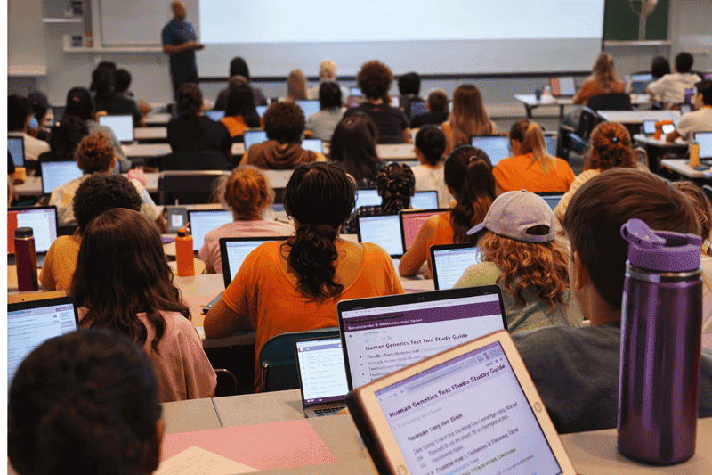 Imagem de estudante assistindo a aula evitando erros que prejudicam o rendimento na faculdade