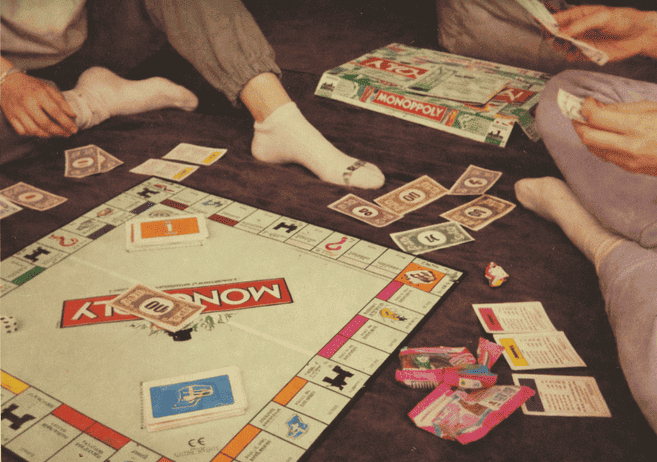 Imagem de amigas jogando jogos de tabuleiro como uma das coisas para fazer em casa com as amigas nas férias