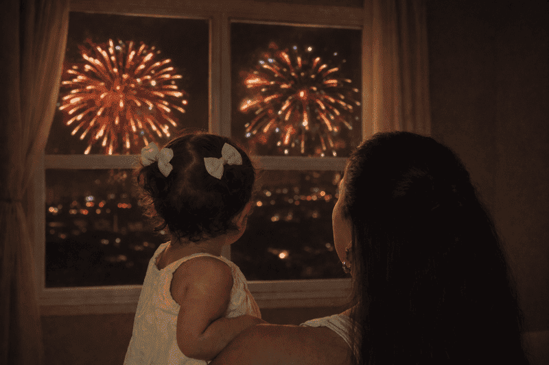 Como proteger o bebe do barulho dos fogos de artificio mae segurando nenem calmo